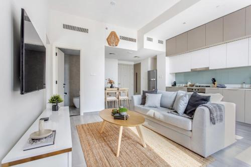 a living room with a couch and a table at Frank Porter - Noor 3 Midtown in Dubai