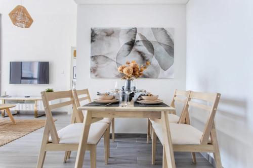 a dining room with a wooden table and chairs at Frank Porter - Noor 3 Midtown in Dubai