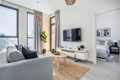 a living room with a couch and a tv at Frank Porter - Noor 3 Midtown in Dubai