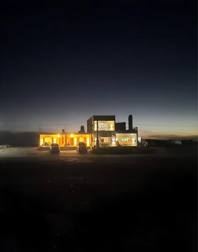 a house at night with cars parked in front of it at Departamentos Las Loicas in San Blás