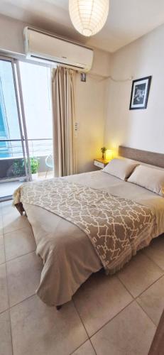 a bedroom with a large bed and a large window at Rent for Days in San Miguel de Tucumán