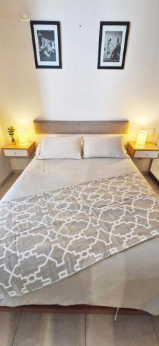 a large bed in a bedroom with two lamps at Rent for Days in San Miguel de Tucumán