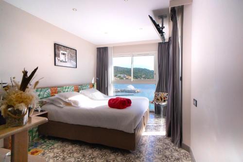 a bedroom with a bed with a red rose on it at Le Golfe in Porto Pollo