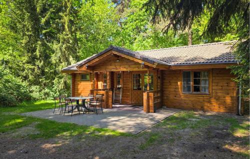 a cabin with a table and chairs in front of it at Cozy Home In Neede With Sauna in Neede
