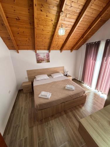 a bedroom with a bed in a room with wooden ceilings at P&K apartment Pogradec in Pogradec