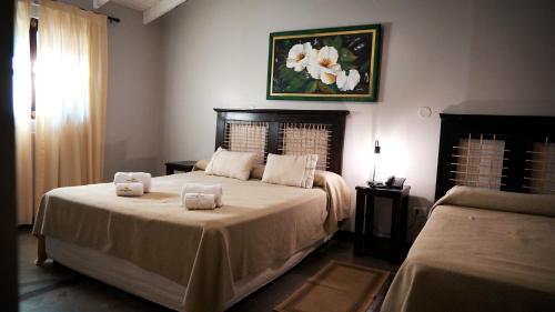 a bedroom with a bed with two towels on it at Hotel Jardín del Paraná in Paso de la Patria