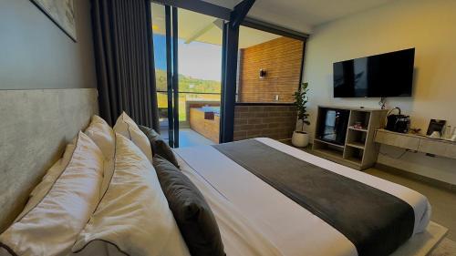 a bedroom with a large bed with a large window at Rooca Habitat Guatape in Guatapé