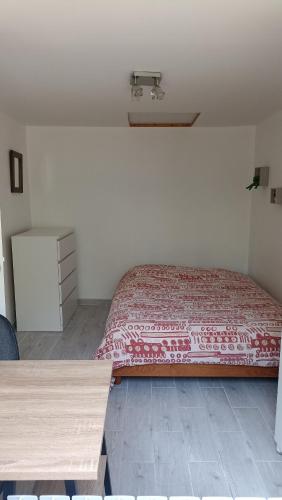 - une chambre avec un lit doté d'un couvre-lit rouge dans l'établissement Maison mes délices, à Caen
