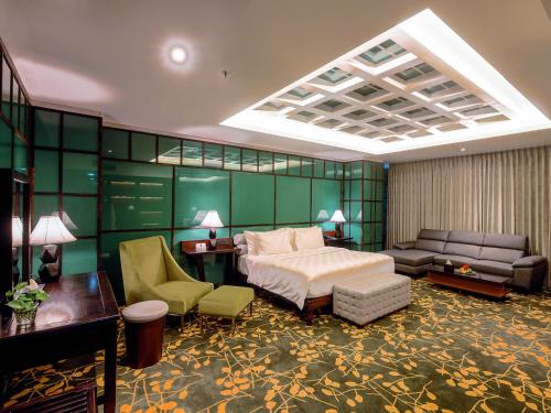 a hotel room with a bed and a couch at Grand Sya Hotel in Palu