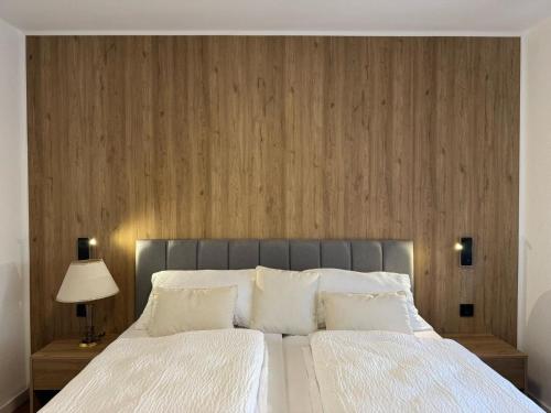 a bedroom with a large bed with a wooden wall at FeWo Böhmeheide Soltau in Soltau