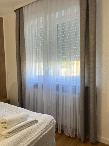 a bedroom with a window with white curtains at FeWo Böhmeheide Soltau in Soltau