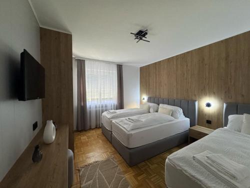 a hotel room with two beds and a television at FeWo Böhmeheide Soltau in Soltau
