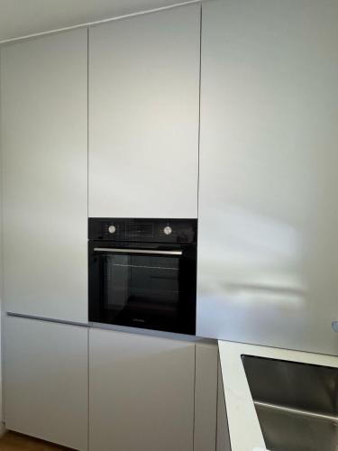 a kitchen with white cabinets and a microwave at FeWo Böhmeheide Soltau in Soltau