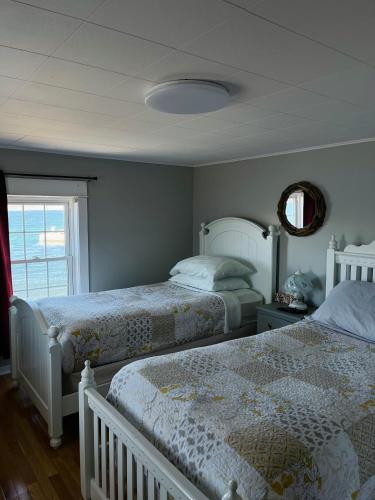 a bedroom with two beds and a window at Toulinguet Inn - Suites in Twillingate