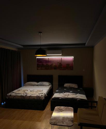 a dark room with two beds and a couch at Hotel sofra in Ferizaj