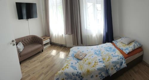a small bedroom with a bed and a couch at Bluestars Home in Karlovy Vary