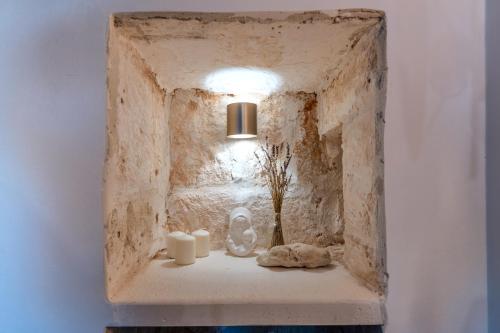 a stone niche with candles and flowers on a shelf at La Casita Ostuni - Authentic Apulian Stay in Ostuni