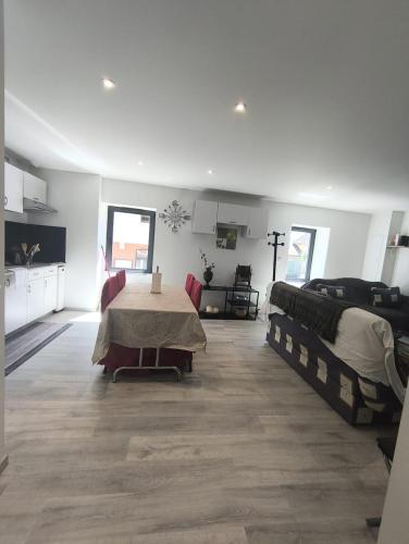 a living room with two beds and a table at Cosy et chaleureux, centre village, proche commodité in Champagne-en-Valromey