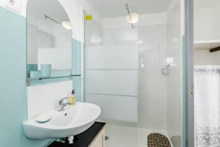 une salle de bain blanche avec un lavabo et une douche dans l'établissement Petite maison proximité mer et port, à La Ciotat