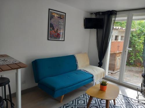 un salon avec un canapé bleu et une fenêtre dans l'établissement Petite maison proximité mer et port, à La Ciotat