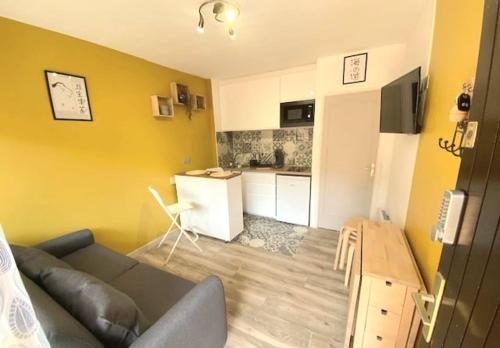 un salon avec un canapé et une cuisine dans l'établissement Le Miradou, avec parking, à Collioure