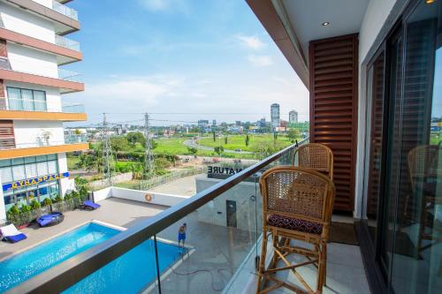 a balcony with a chair and a swimming pool at The Steward Dwellings@Signature in Accra
