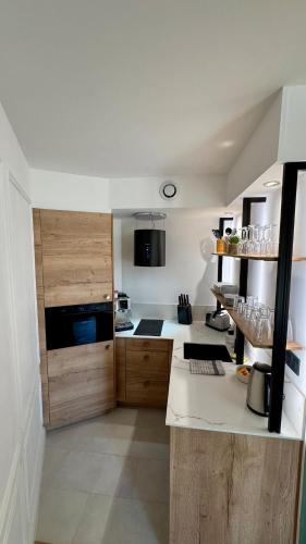 une cuisine avec des armoires en bois et un comptoir dans l'établissement Le Jeanne d'Arc -Best quality - Amiens Center, à Amiens