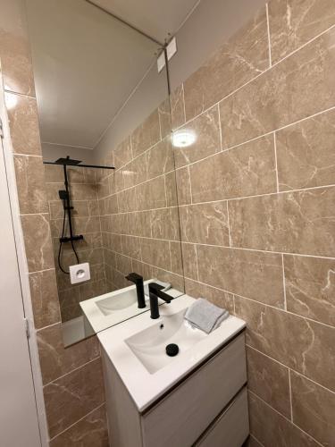 une salle de bain avec un lavabo et un miroir dans l'établissement studio centre ville, à Narbonne