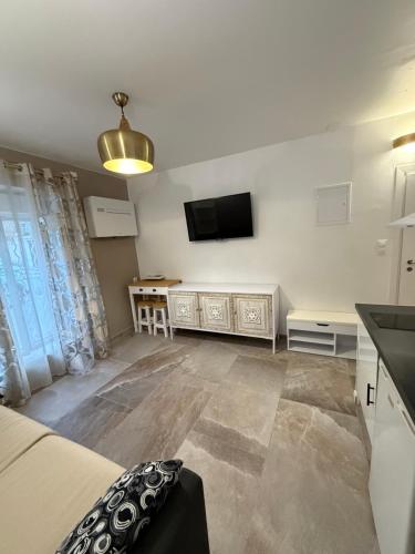 un salon avec un lit et une télévision à écran plat dans l'établissement studio centre ville, à Narbonne