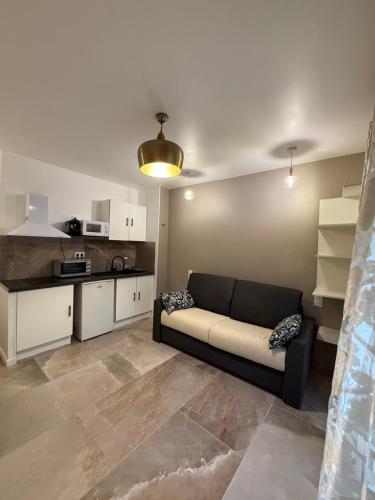 un salon avec un canapé et une cuisine dans l'établissement studio centre ville, à Narbonne
