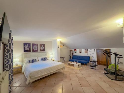 a bedroom with a bed and a blue couch at 49 Sea Rooms - Guesthouse by Host Hero in Stintino