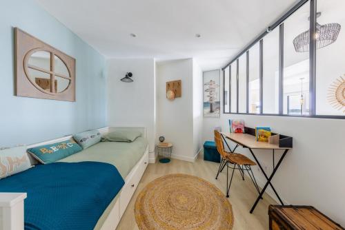 una camera da letto con un letto e una scrivania di Appartement vue mer, Arcachon 3 étoiles ad Arcachon