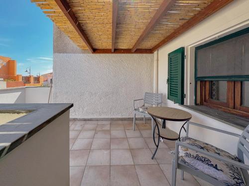 a patio with a table and chairs on a balcony at 49 Sea Rooms - Guesthouse by Host Hero in Stintino