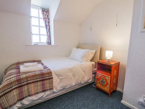 a small bedroom with a bed and a night stand at Pen Y Bryn Bach in Harlech