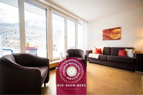a buss brain beer sign in a room with chairs and a couch at Chasa Tulai F83 in Scuol