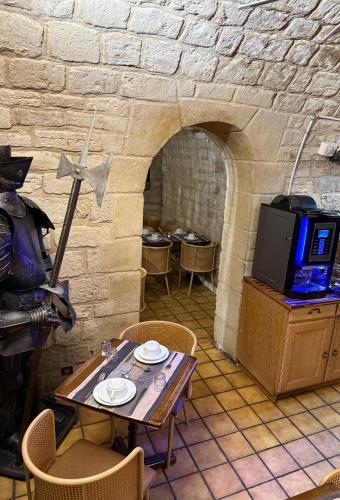 Cette chambre dispose d'une table et d'une télévision dans un mur en pierre. dans l'établissement Hotel Richmond Gare du Nord, à Paris