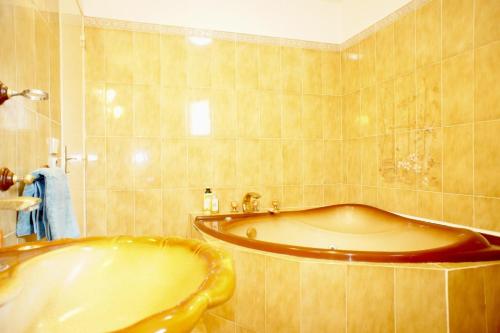 a bathroom with a large tub and a sink at I Melograni 8 personnes in Chomérac