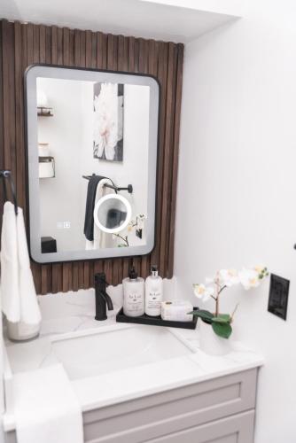 a bathroom with a mirror and a white sink at Luxurious Home Away From Home in Pickering