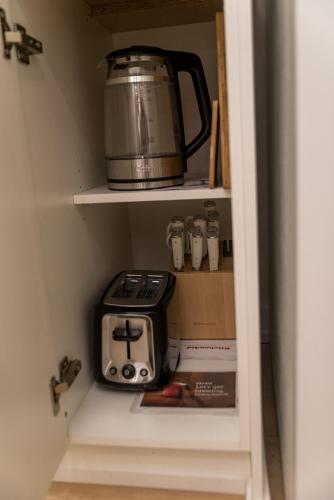 a coffeemaker sitting on a shelf in a kitchen at Luxurious Home Away From Home in Pickering