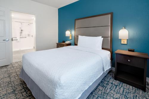 a bedroom with a large bed and a blue wall at Homewood Suites by Hilton Eatontown in Eatontown