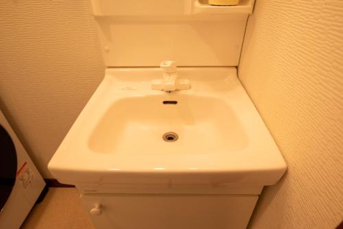 a bathroom with a white sink in a room at BREEZE furano 202 in Furano