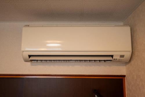 a white air conditioner hanging from a ceiling at BREEZE furano 202 in Furano