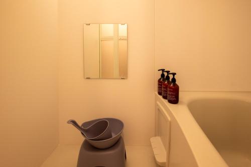 a bathroom with a bath tub and a mirror at BREEZE furano 202 in Furano