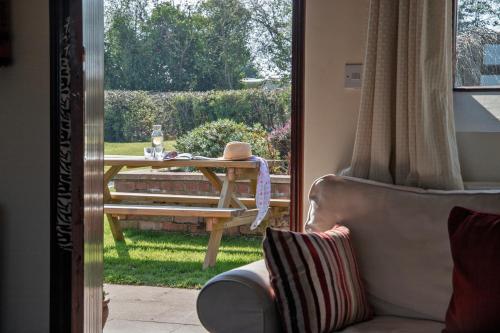 a table and a chair in a room with a window at Zoe's Cottage with Alpaca's and 7 mins drive to Alton Towers in Denstone
