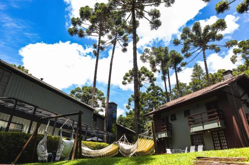 a group of hammocks in front of a building at I am Boutique Hotel Campos do Jordão by Unna in Campos do Jordão