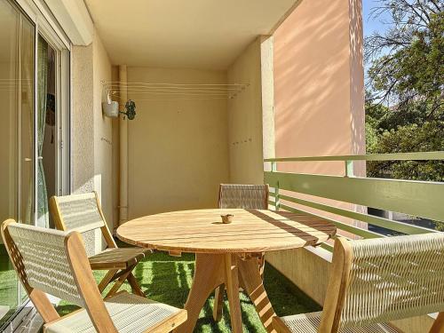 une table et des chaises en bois sur un balcon dans l'établissement Grand Appartement - 3 minutes de la Plage - Les Frères de la Loc', à Marseille