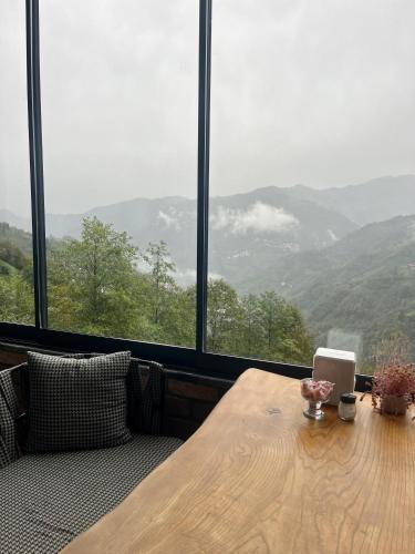 a wooden table with a laptop on it in front of a window at relax dağ evleri king oda in Çamlıhemşin