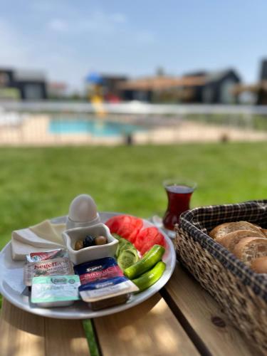 a plate of food with a basket of bread and vegetables at Serenity Village Belek in Belek