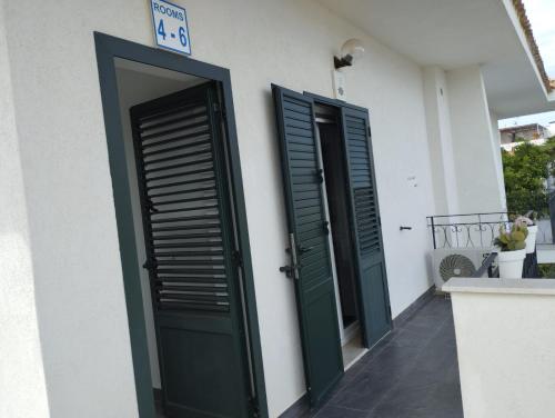 two green doors on the side of a building at Fiore di Loto Rooms in Carini