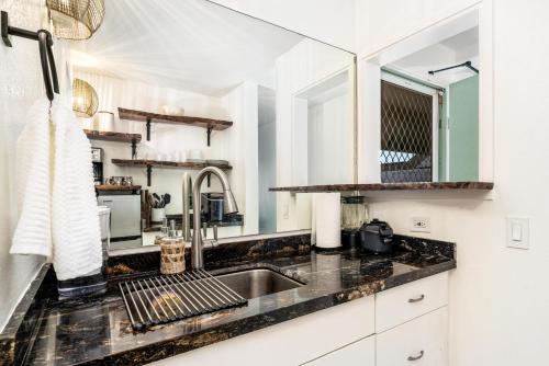 a kitchen with a sink and a mirror at Big Island Kona Islander #341 by Coldwell Banker Island Vacations in Kailua-Kona